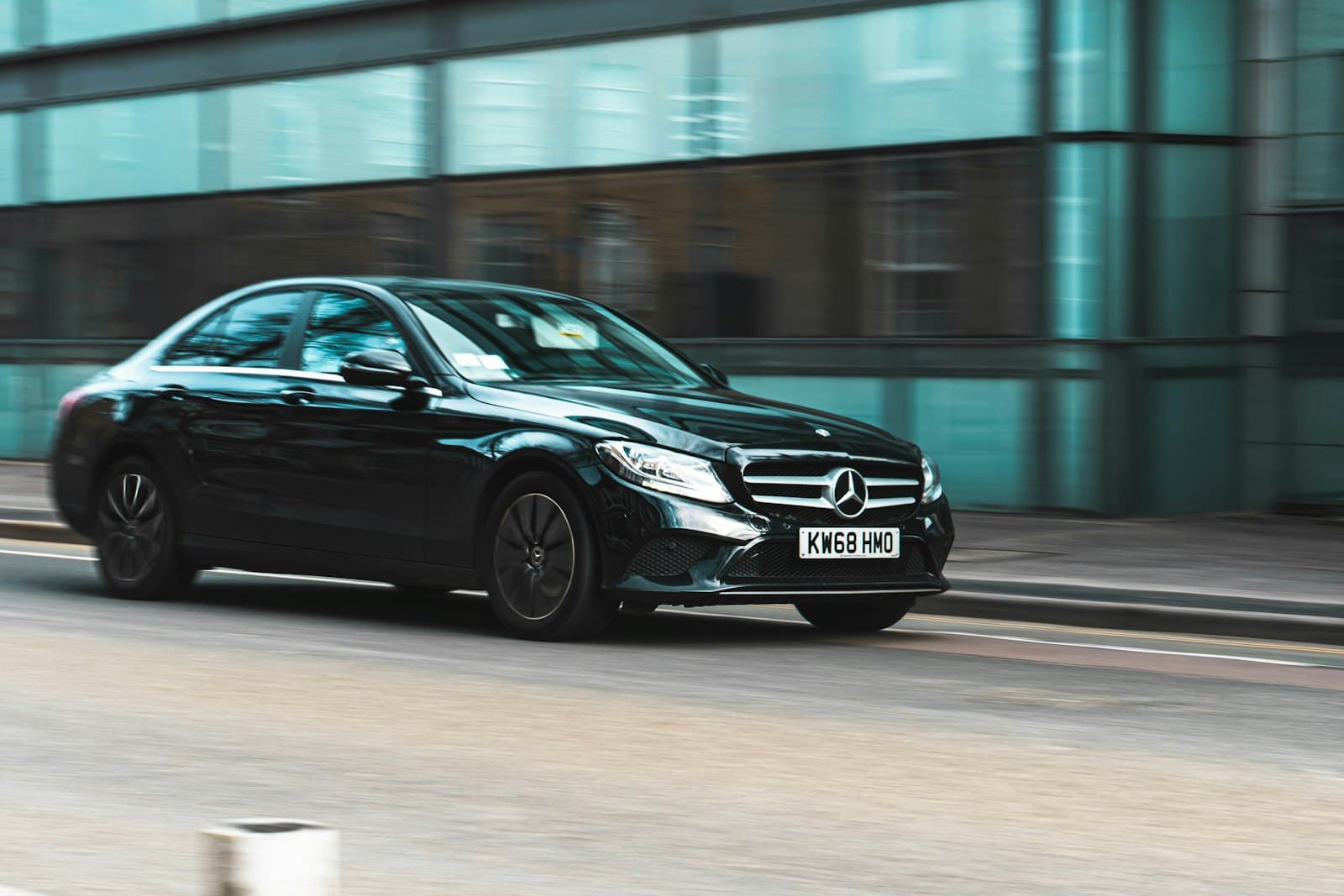 Taxi Mercedes noir en mouvement dans une ville de Flandre